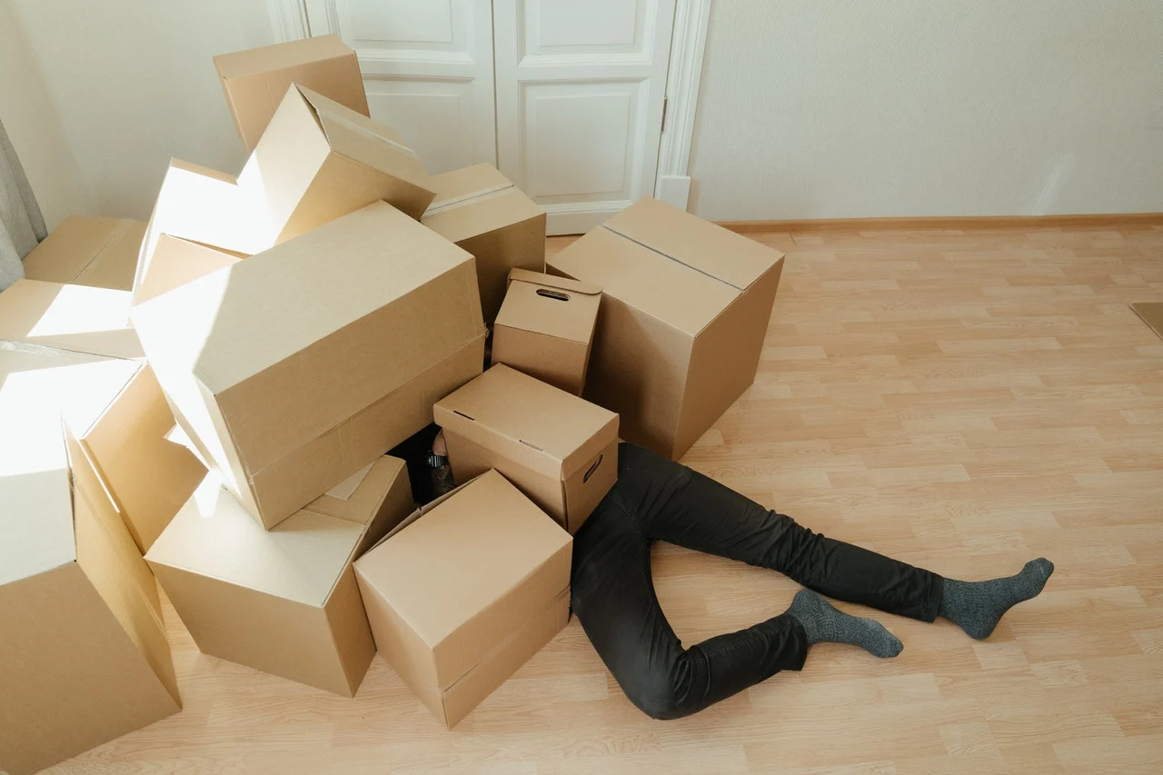 man under moving boxes
